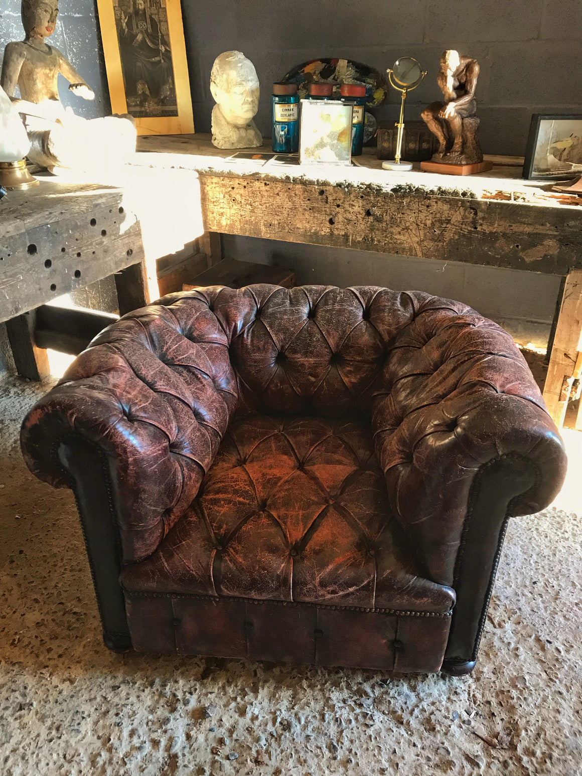 An oxblood Chesterfield armchair with button back and seat