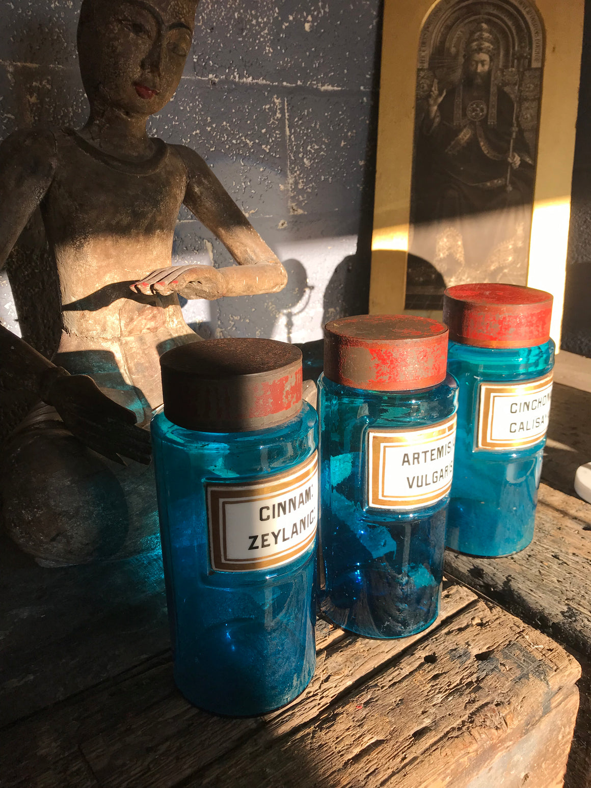 A set of three blue glass apothecary jars with toleware lids