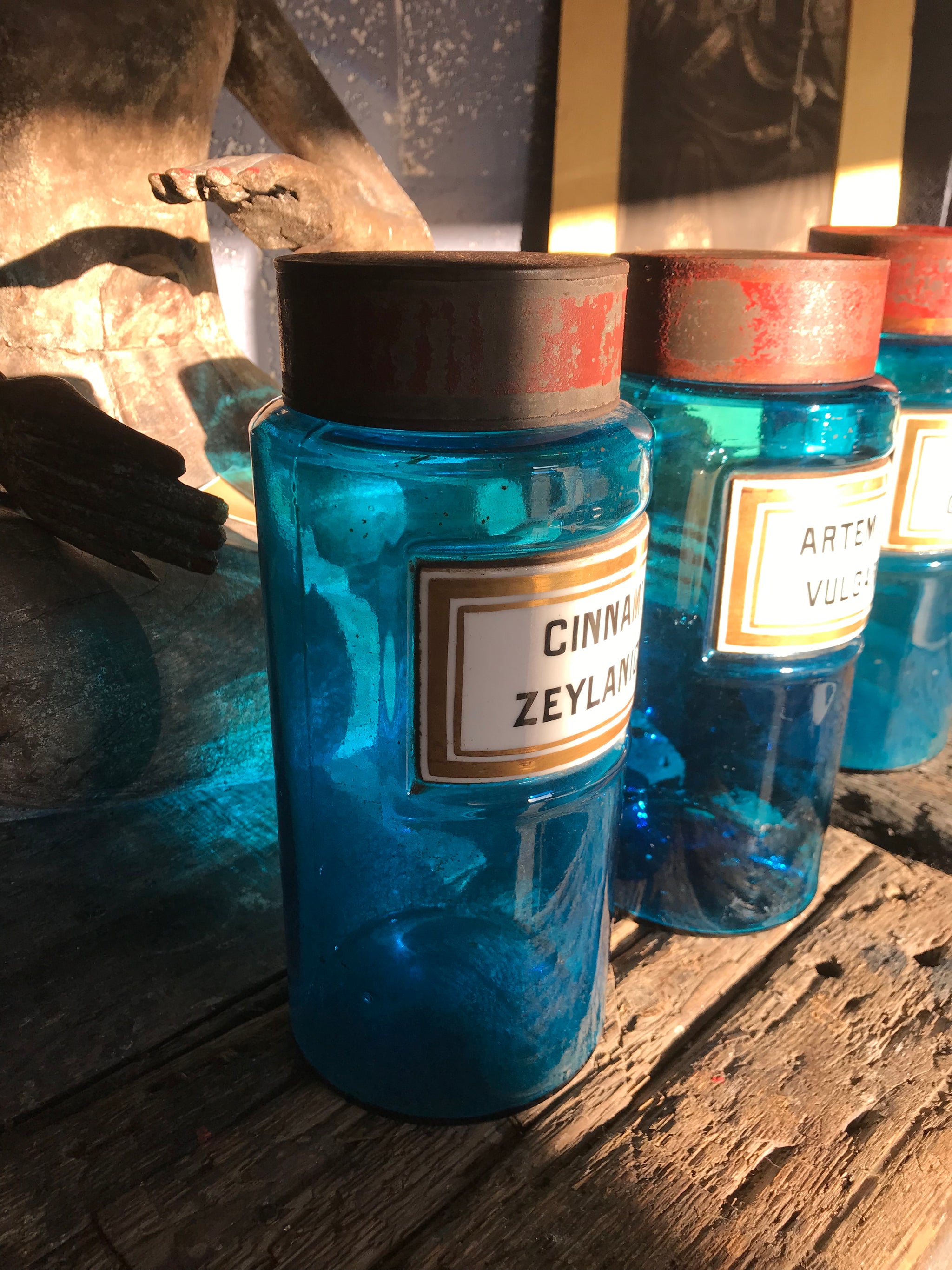 A set of three blue glass apothecary jars with toleware lids