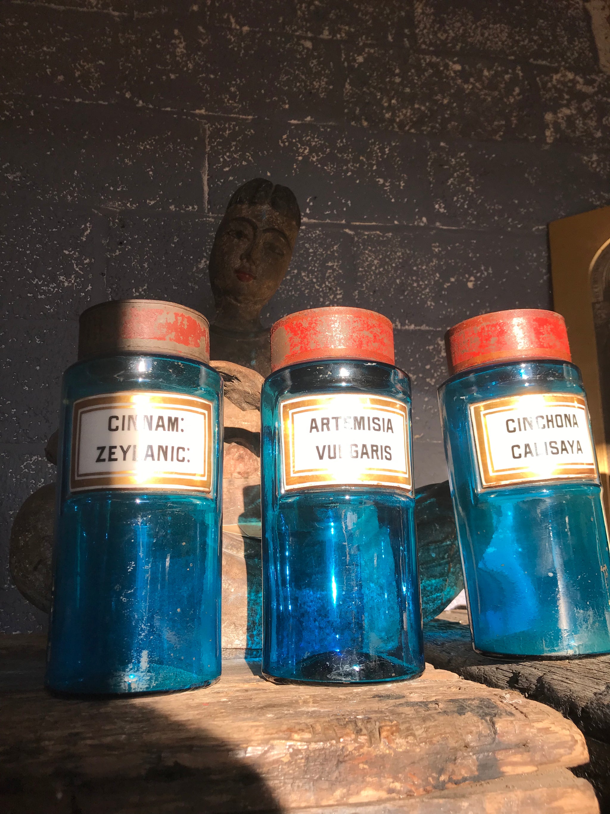 A set of three blue glass apothecary jars with toleware lids