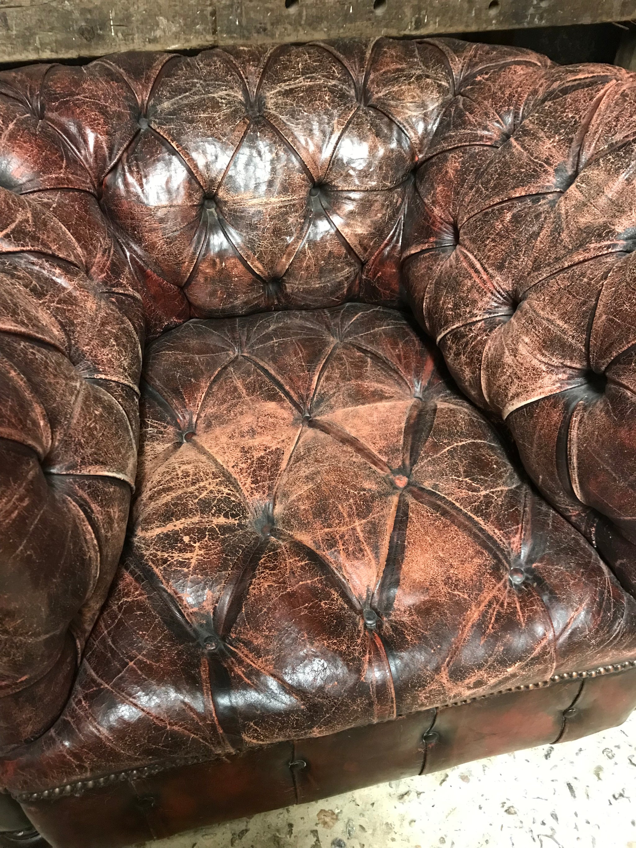 An oxblood Chesterfield armchair with button back and seat