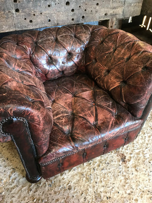 An oxblood Chesterfield armchair with button back and seat