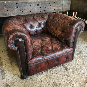 An oxblood Chesterfield armchair with button back and seat