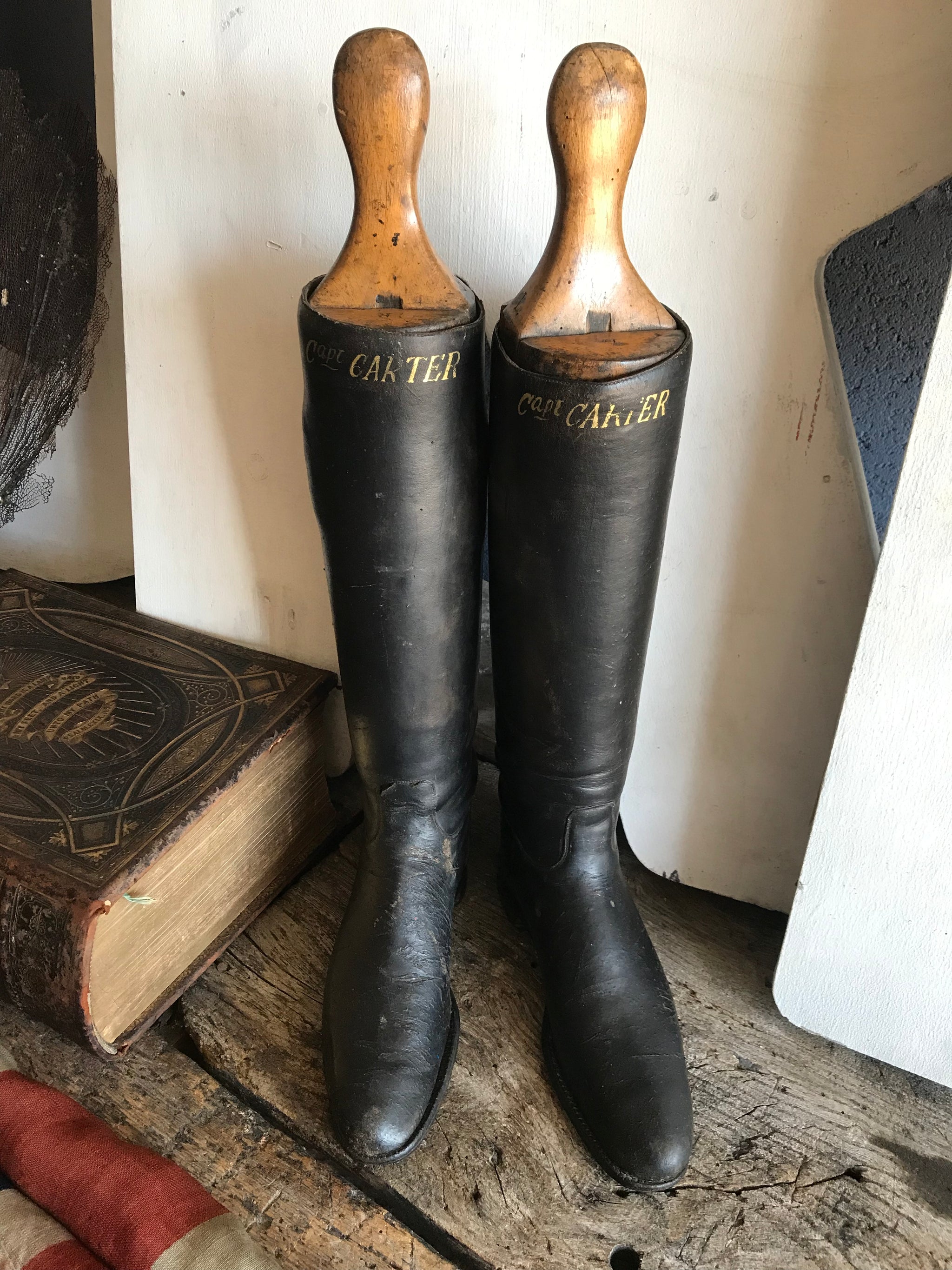 A pair of black leather riding boots with wooden lasts