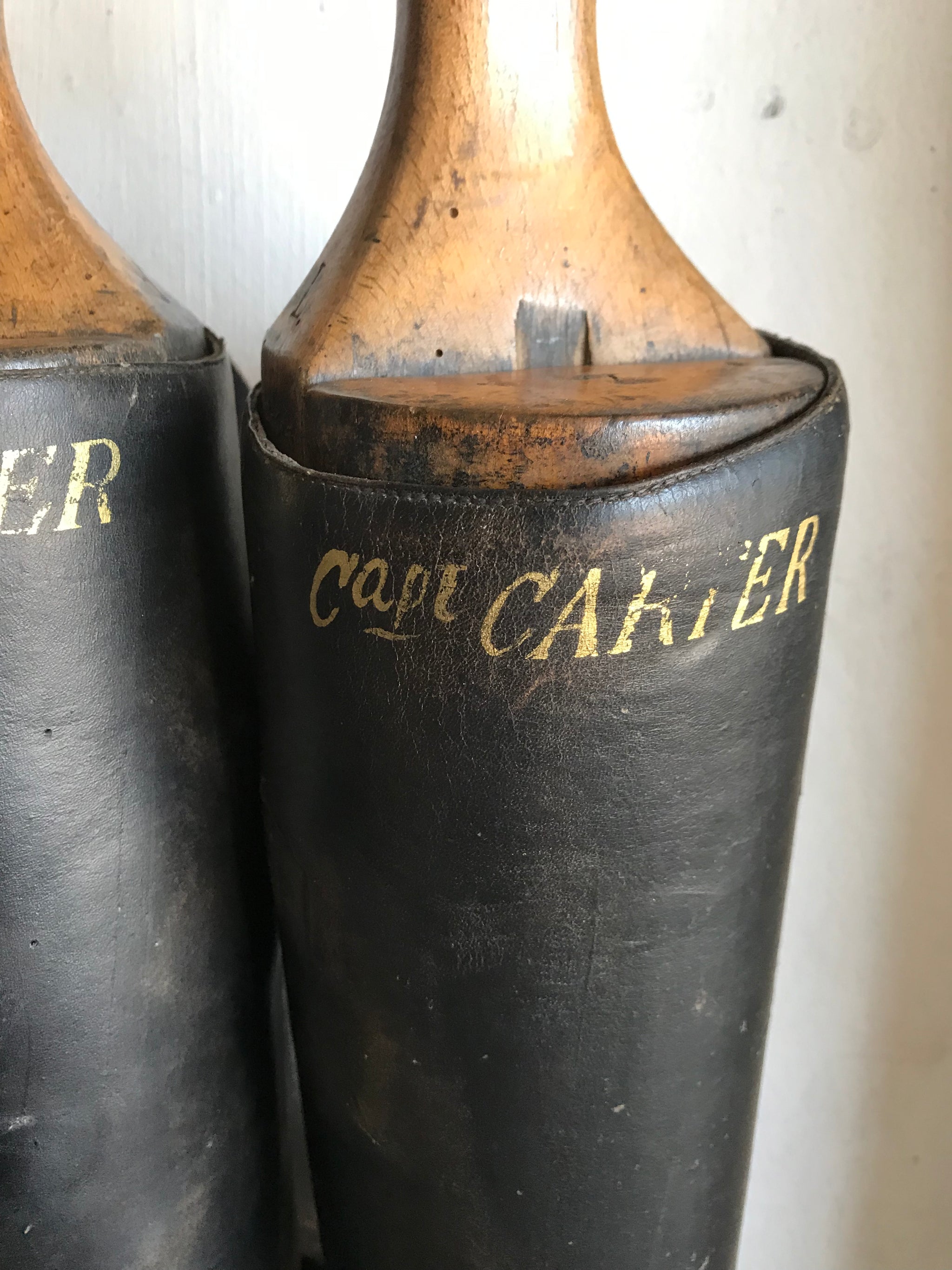 A pair of black leather riding boots with wooden lasts