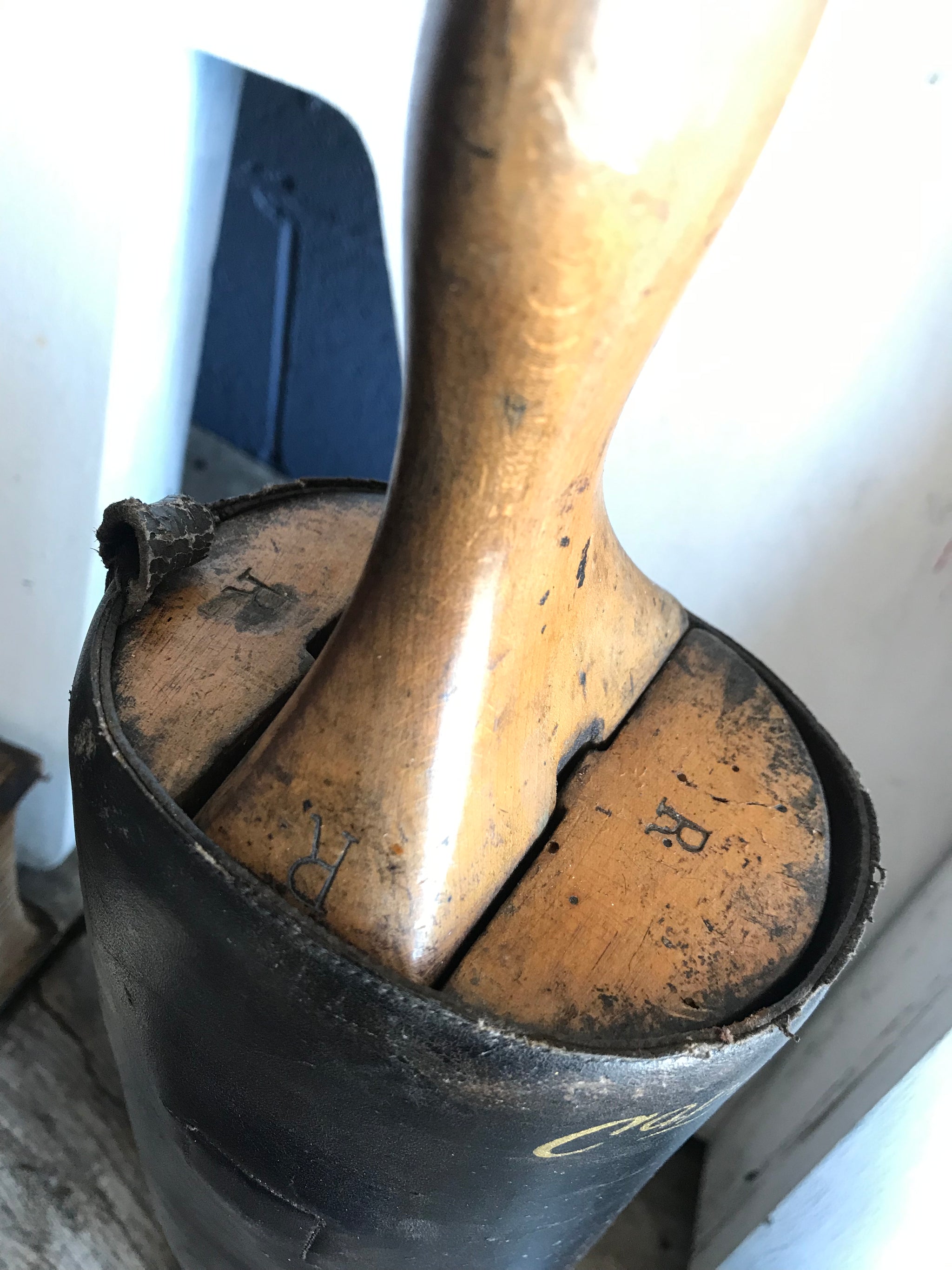 A pair of black leather riding boots with wooden lasts