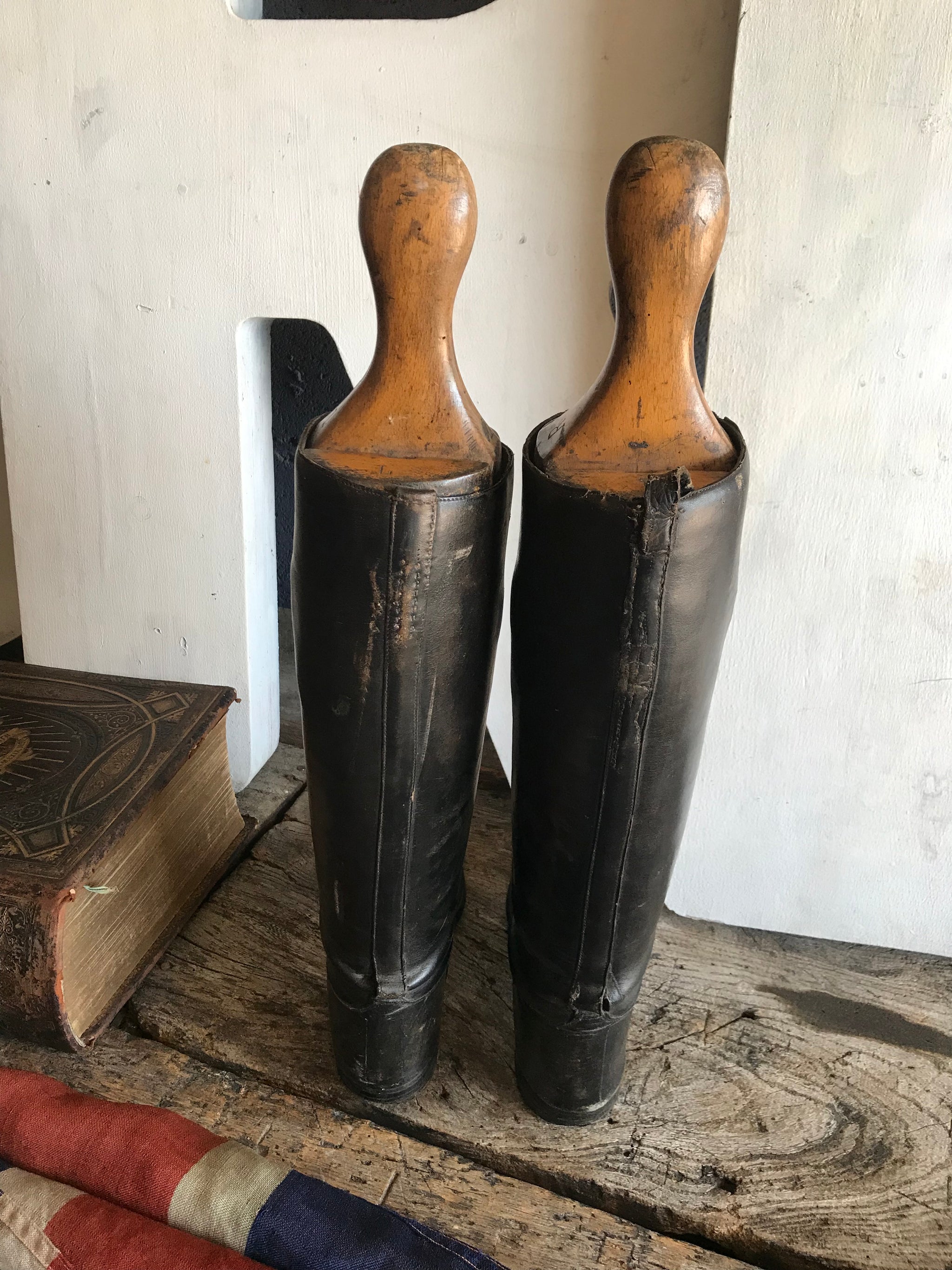 A pair of black leather riding boots with wooden lasts