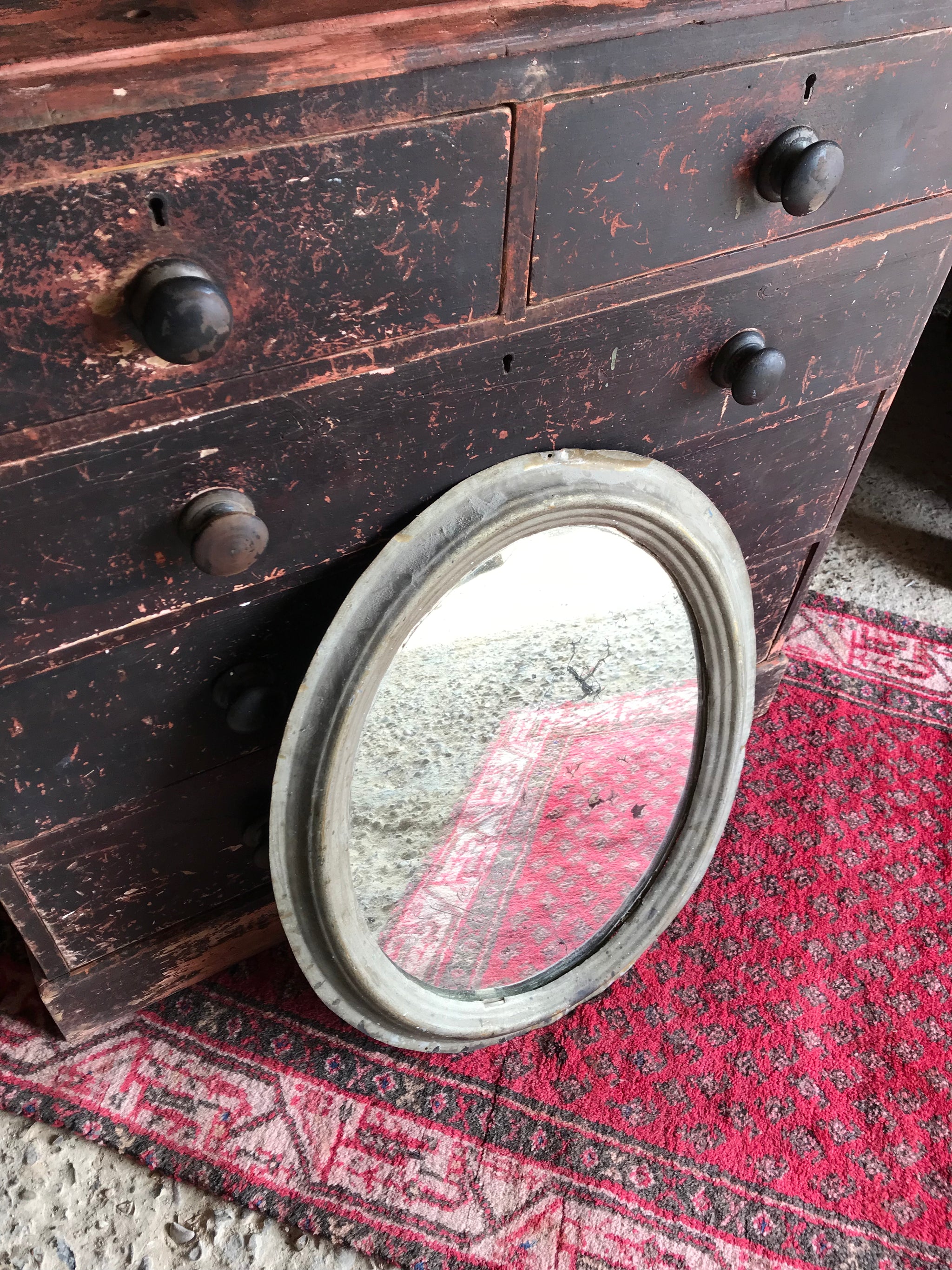 A distressed oval gilt wall mirror