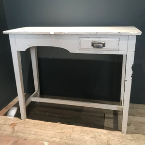 A slim white console table with single drawer