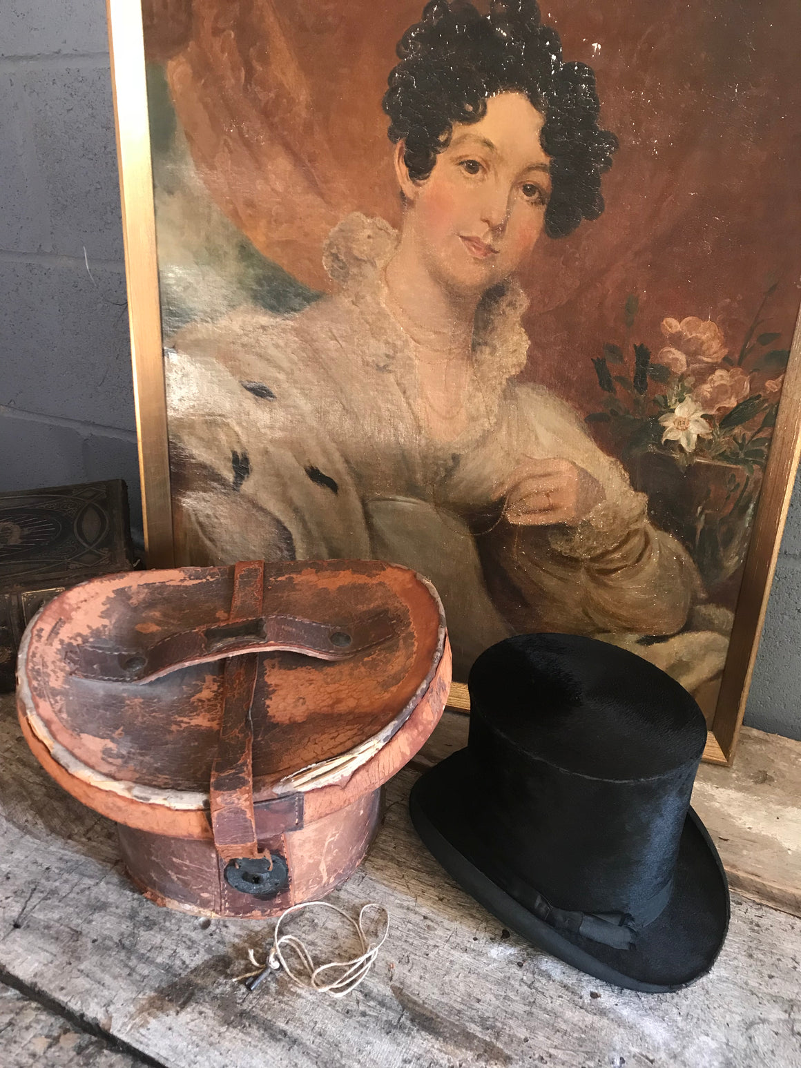 A Victorian silk black top hat and leather hatbox with key