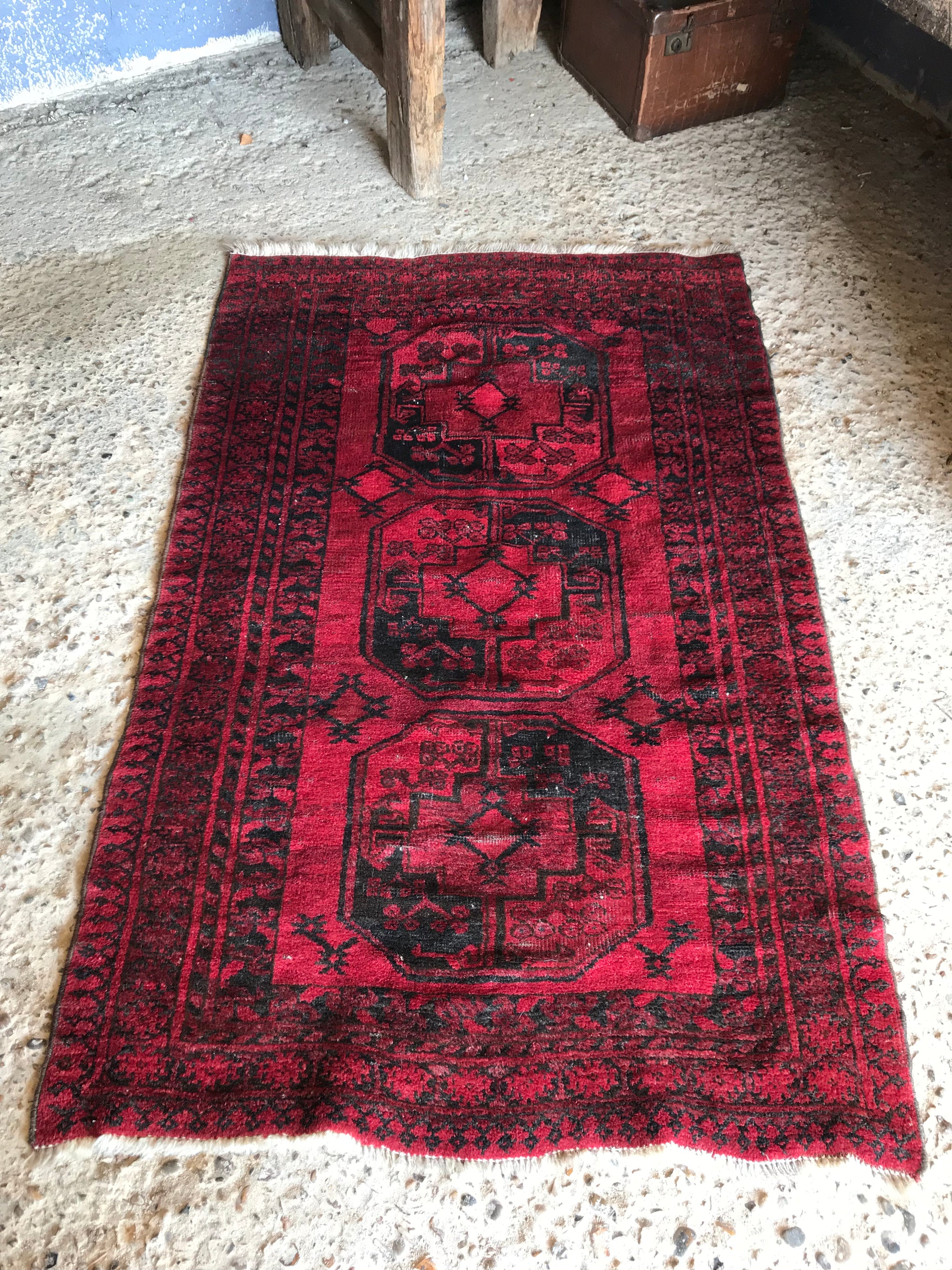 A Persian red ground lozenge rectangular rug
