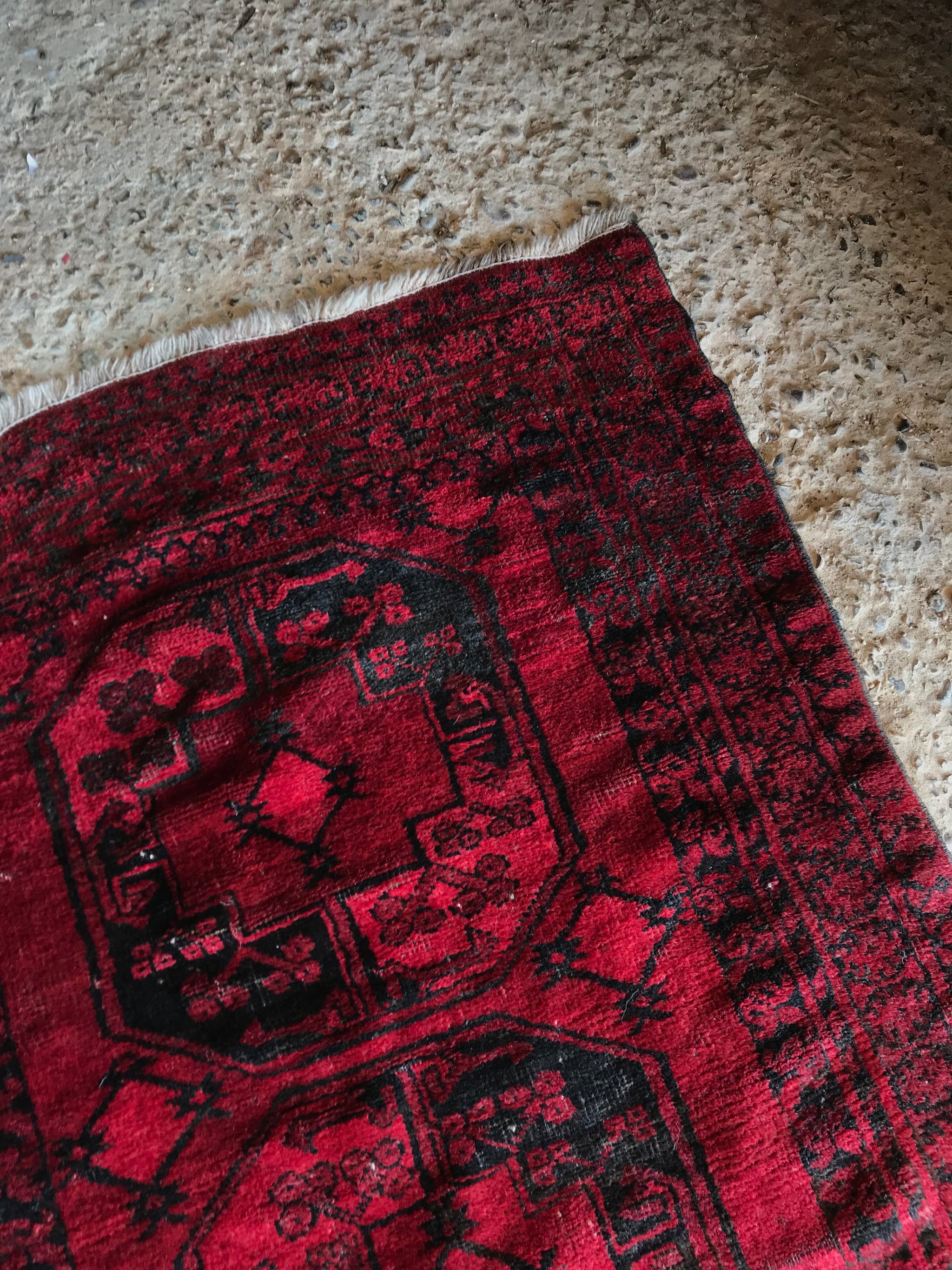 A Persian red ground lozenge rectangular rug