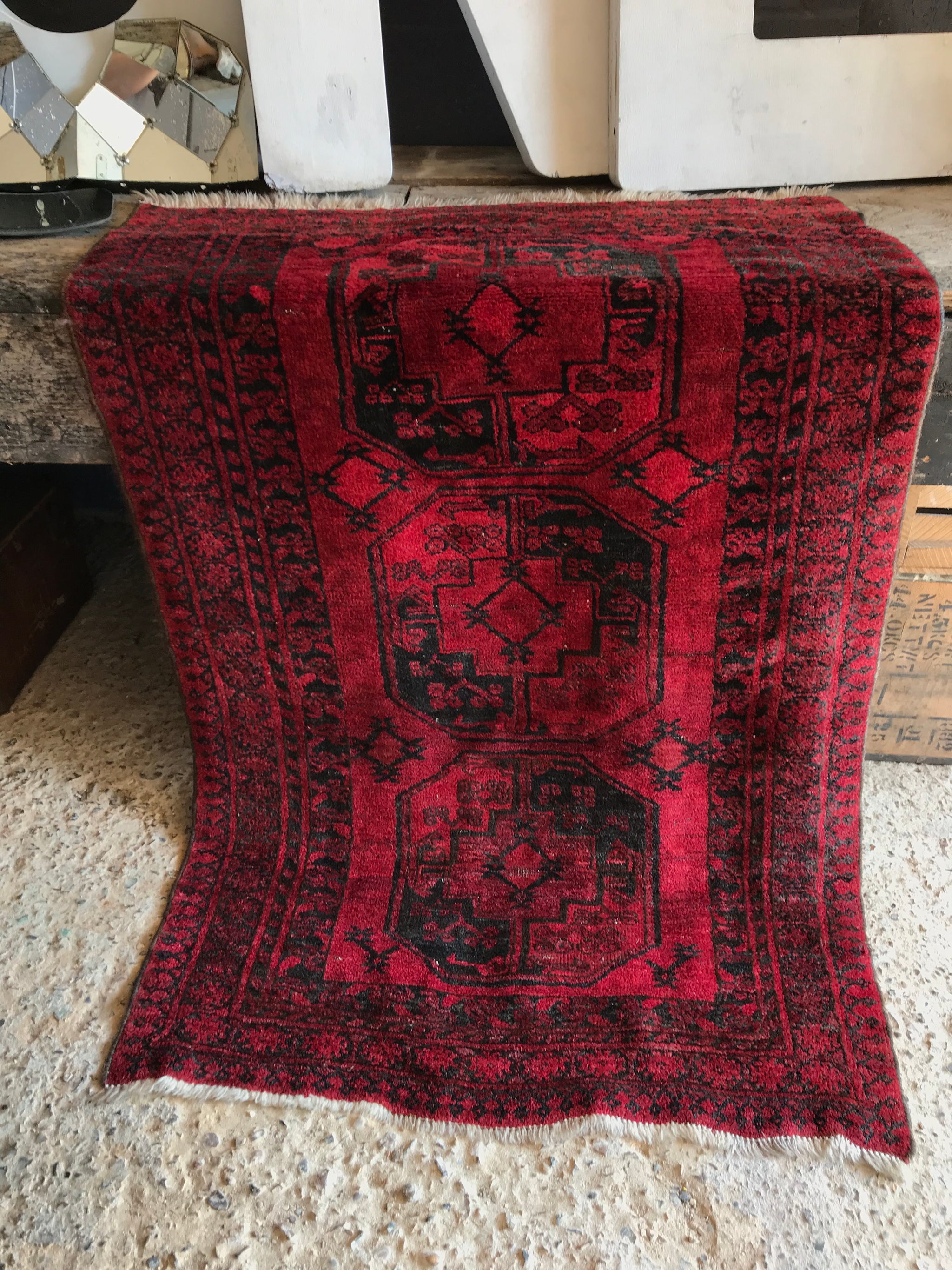 A Persian red ground lozenge rectangular rug