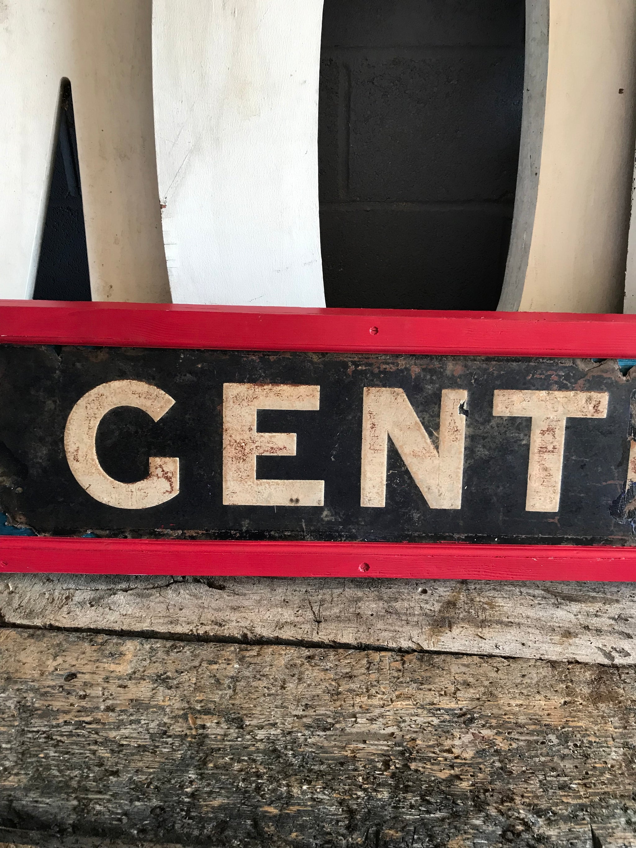 A large enamel GENTLEMEN sign in a wooden frame