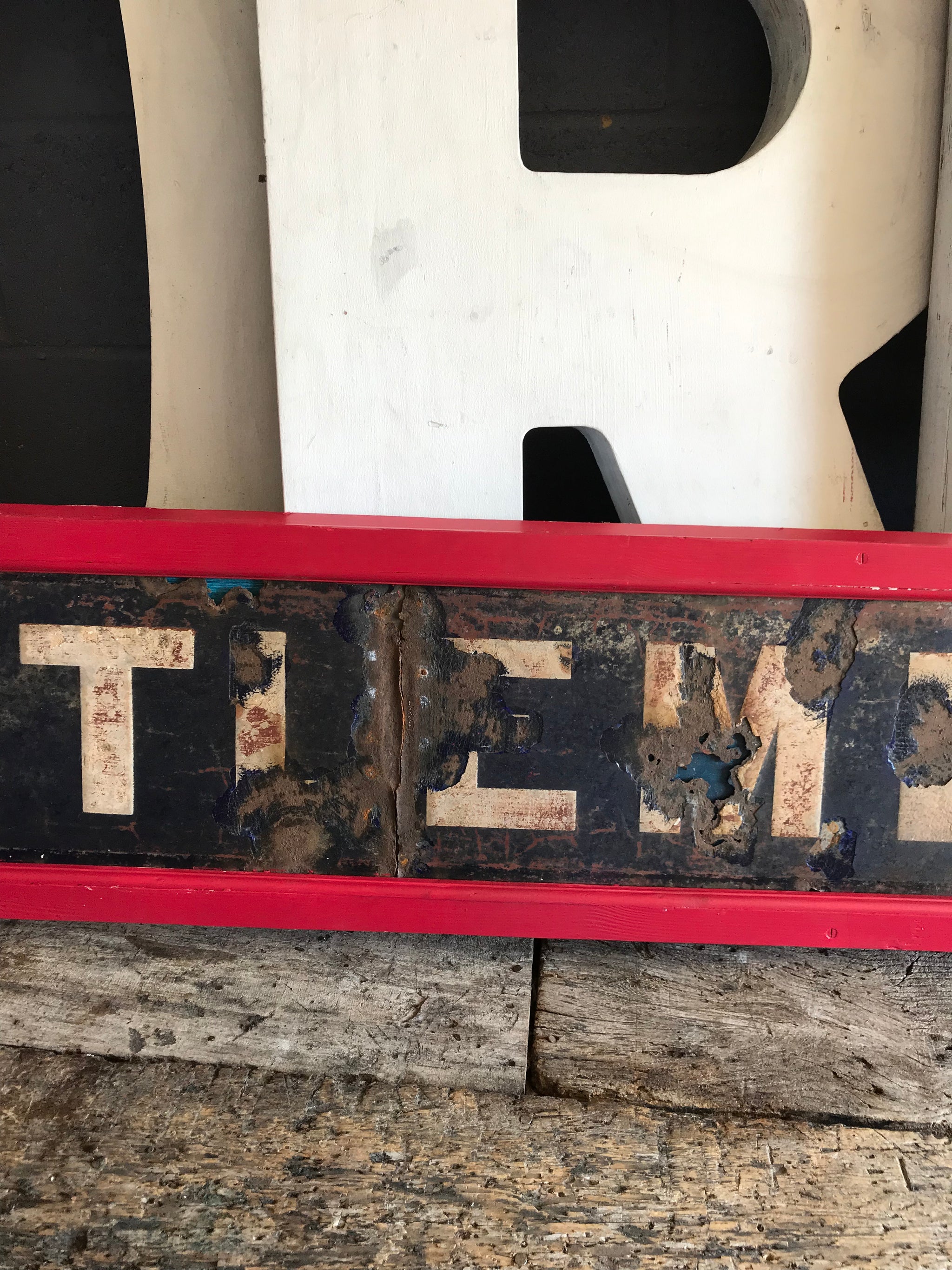 A large enamel GENTLEMEN sign in a wooden frame