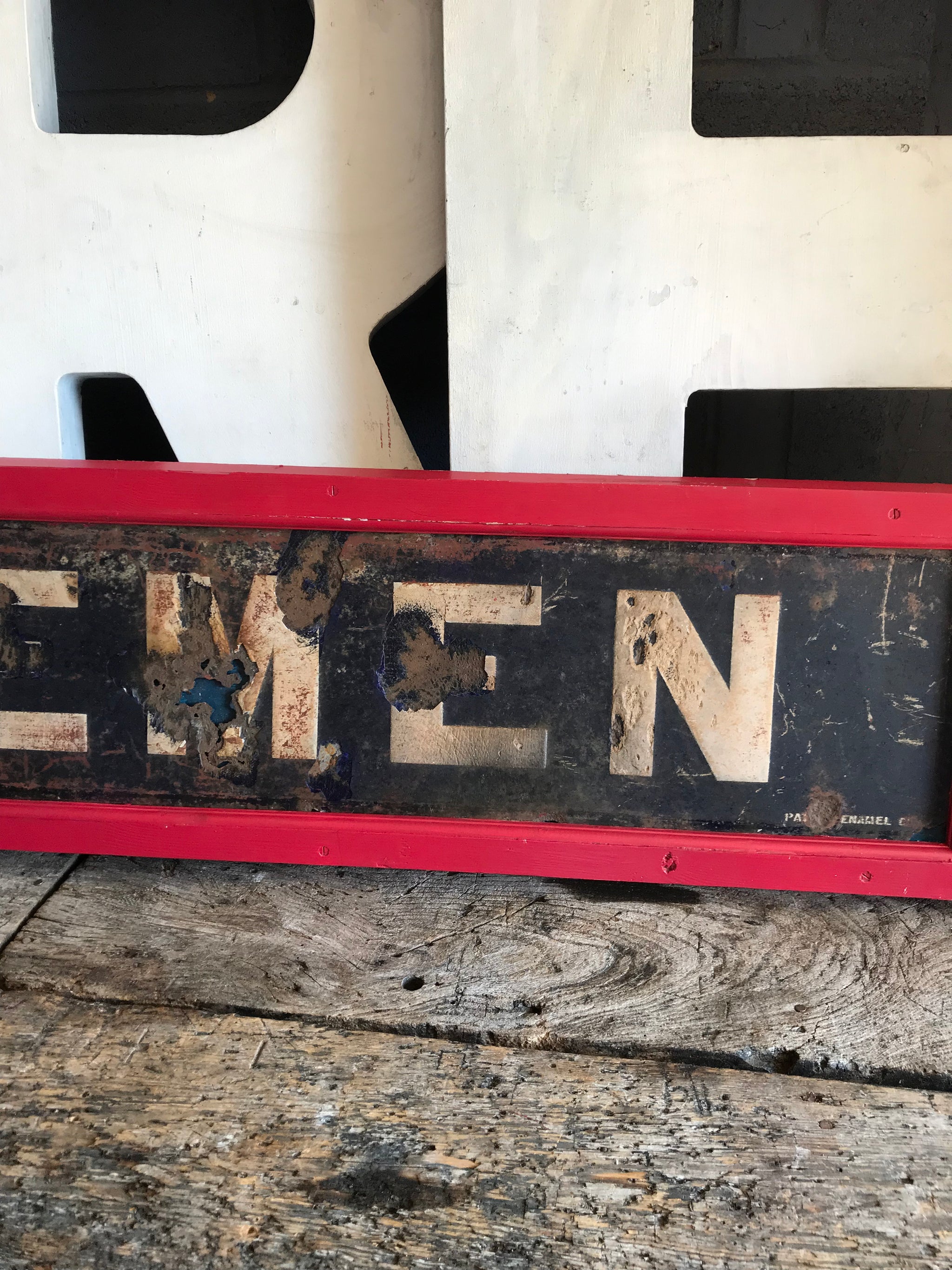 A large enamel GENTLEMEN sign in a wooden frame