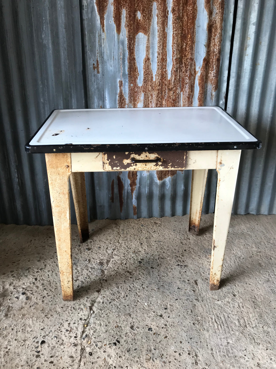 A rustic metal table with enamel top