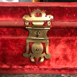 An ornate red velvet and brass vanity case