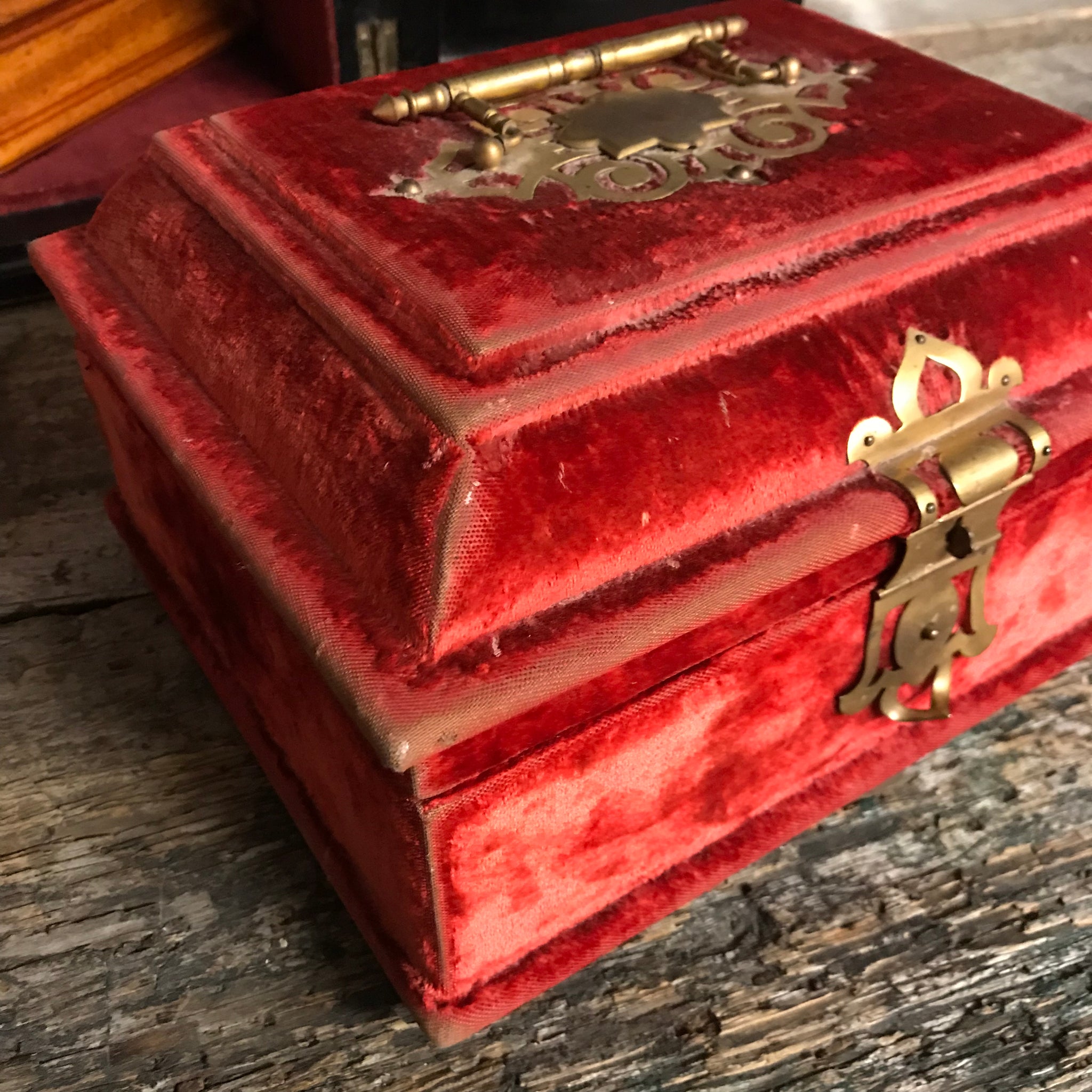 An ornate red velvet and brass vanity case
