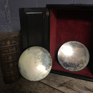 A pair of distressed parabolic mirrors