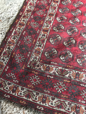 A Persian red ground lozenge rectangular rug