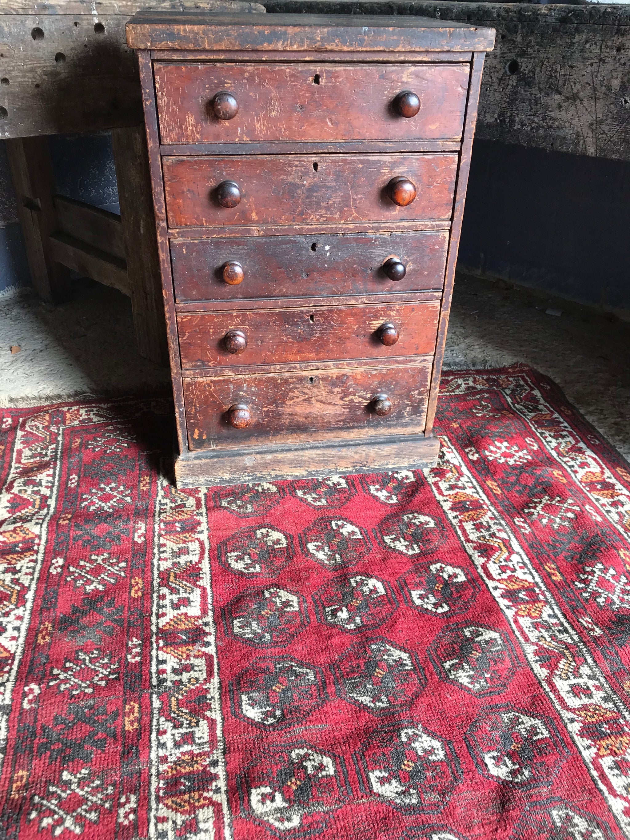 A Persian red ground lozenge rectangular rug