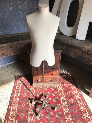 A cream male mannequin with cast iron pedal base and castors