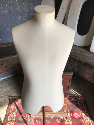 A cream male mannequin with cast iron pedal base and castors