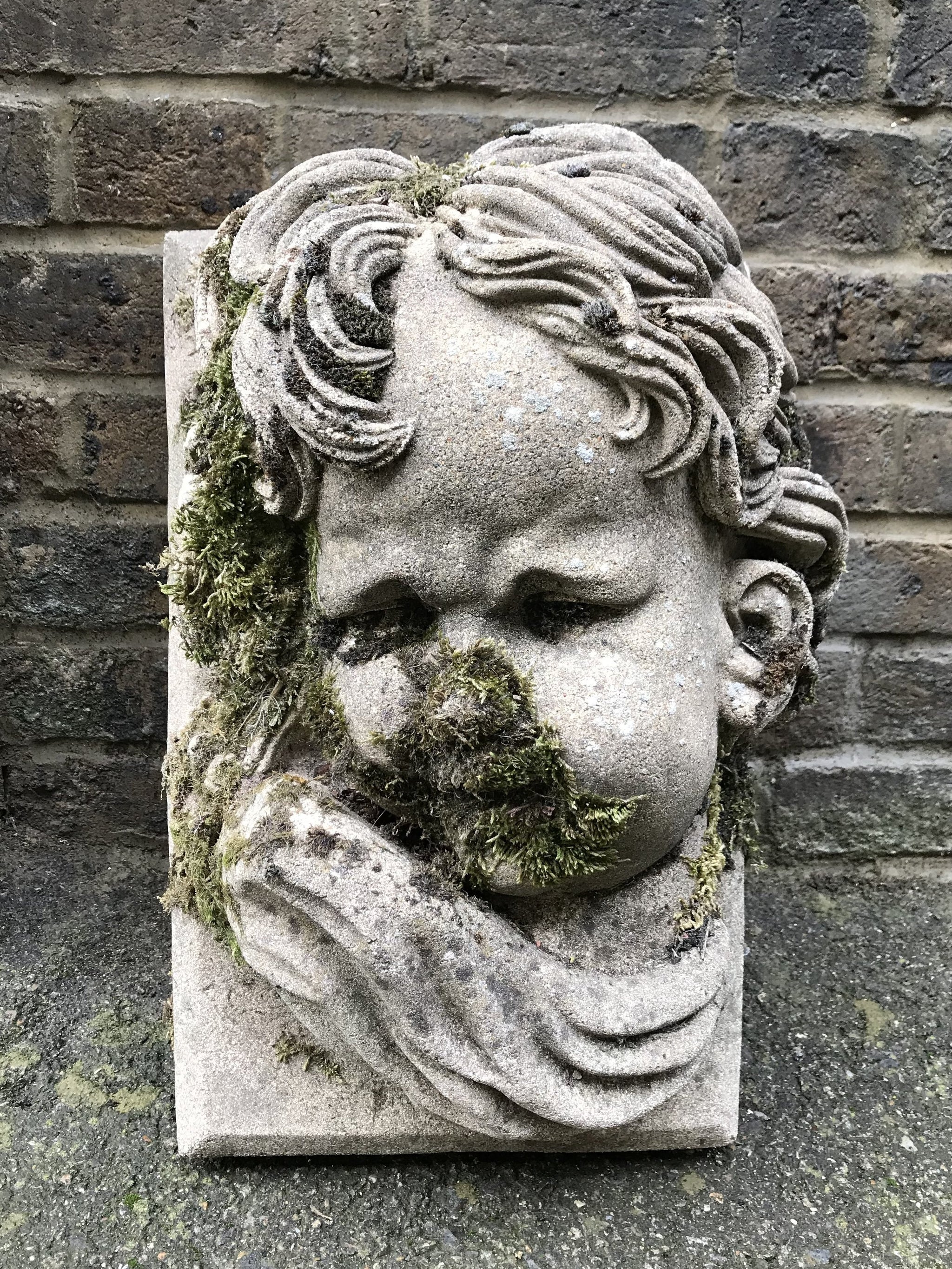 A weathered putti keystone