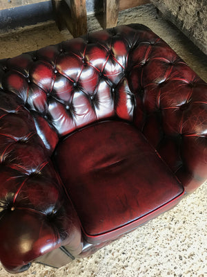 An oxblood red Chesterfield armchair with button back