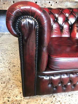 An oxblood red Chesterfield armchair with button back
