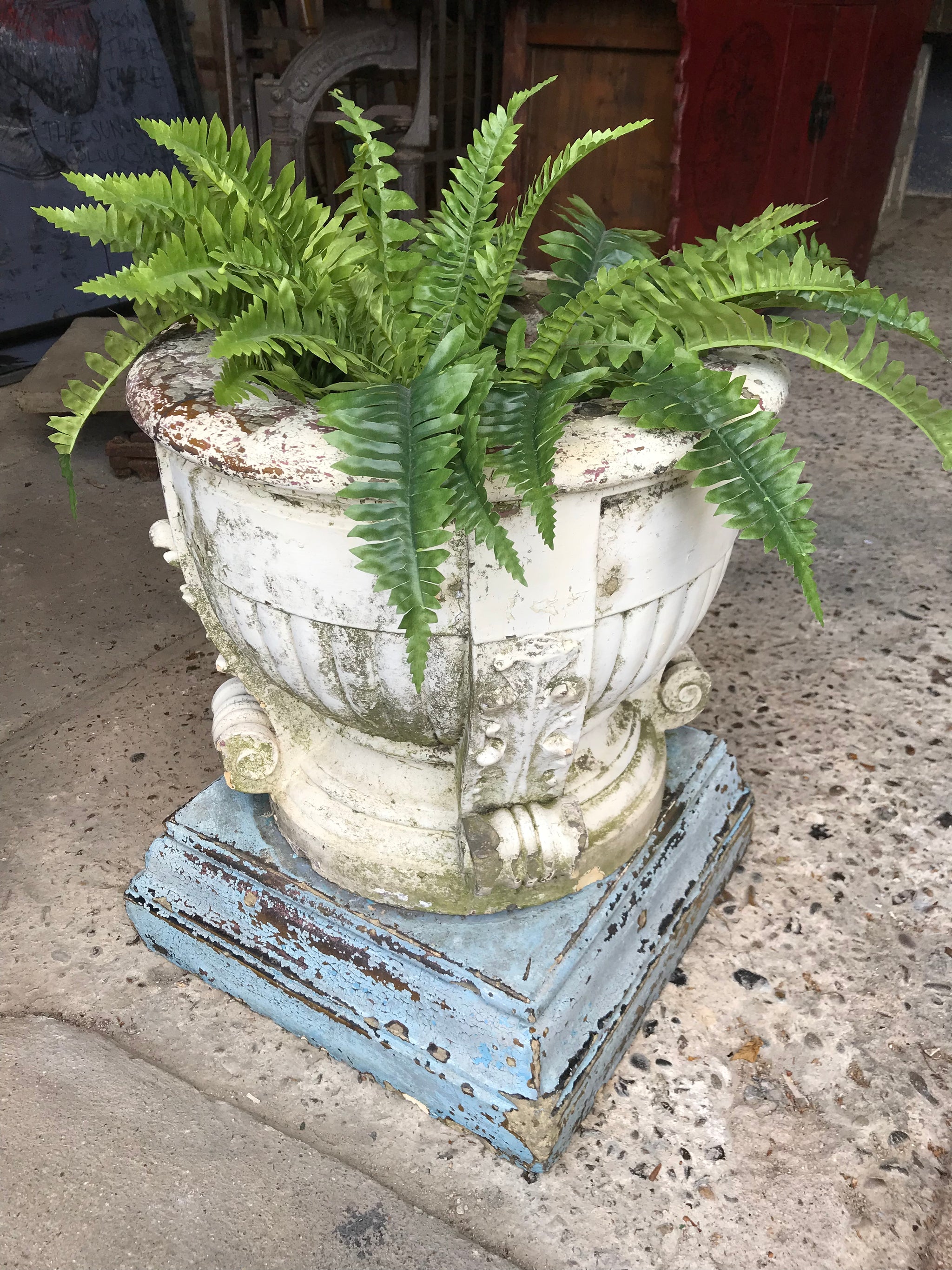 A large terracotta country house urn on plinth