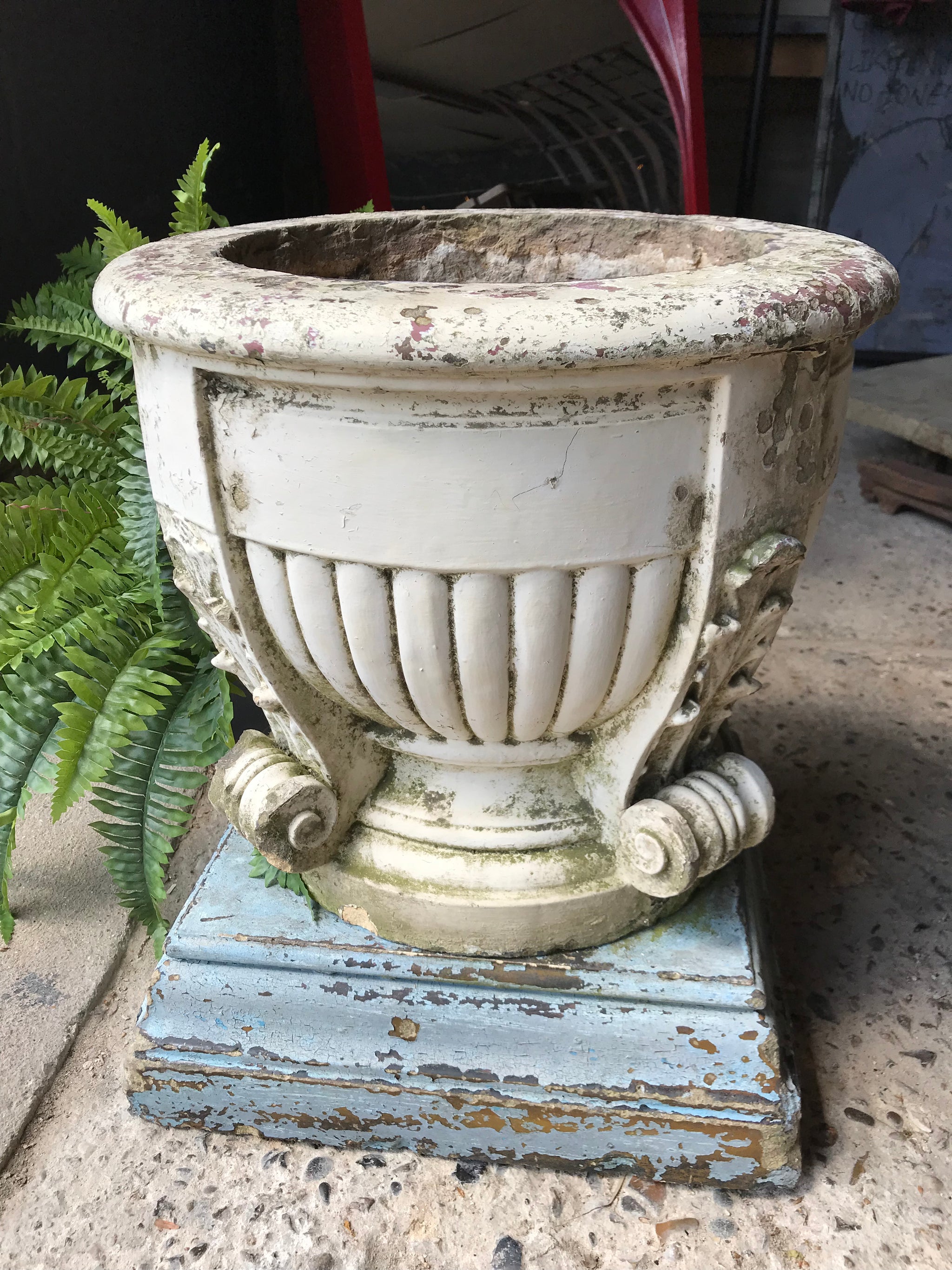 A large terracotta country house urn on plinth