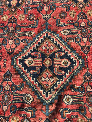 A rectangular red ground wool Persian rug