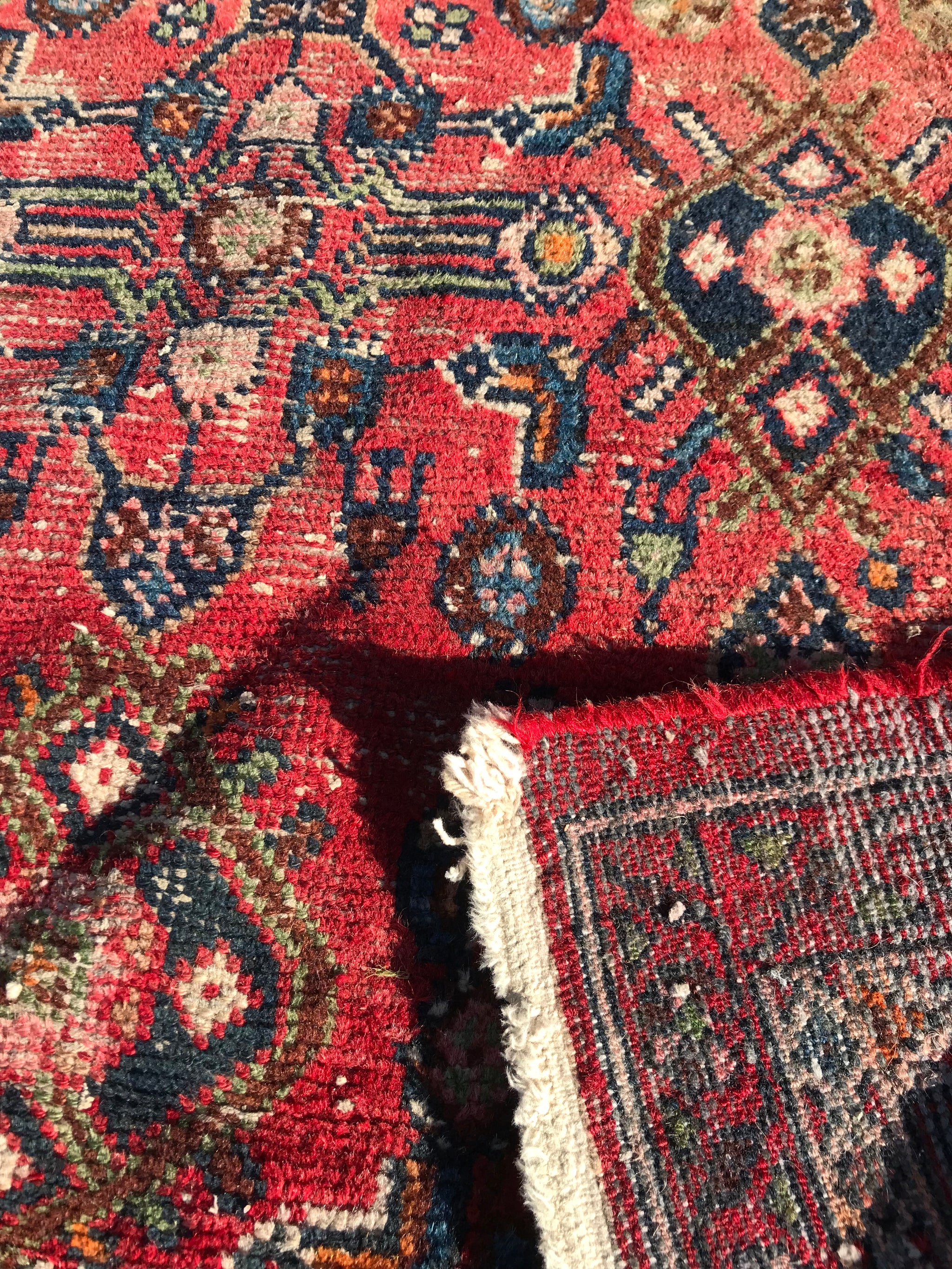 A rectangular red ground wool Persian rug