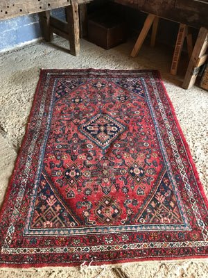 A rectangular red ground wool Persian rug
