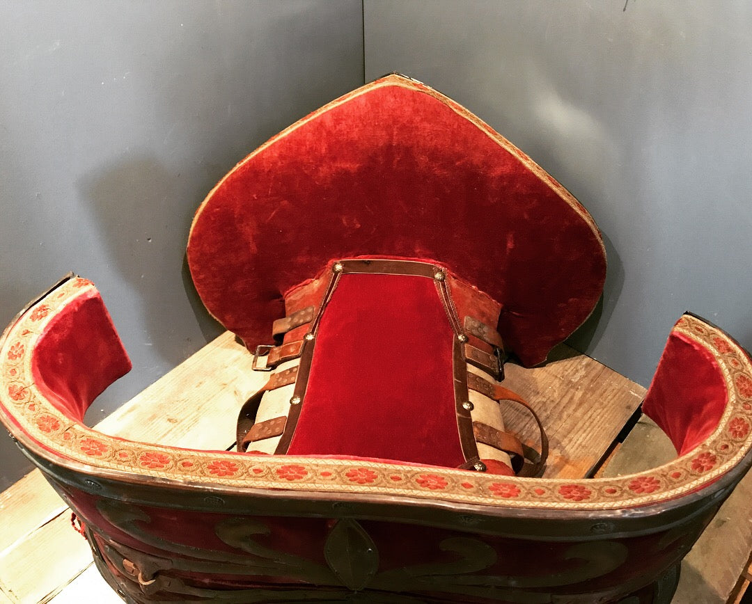 A red velvet and worked metal horse saddle