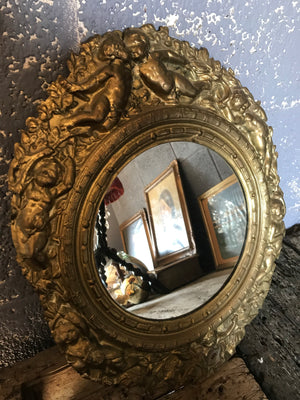 A pair of 19th Century brass repoussé mirrors with cherub detailing