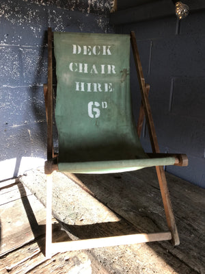 An old deck chair with mint green canvas stencilled seat