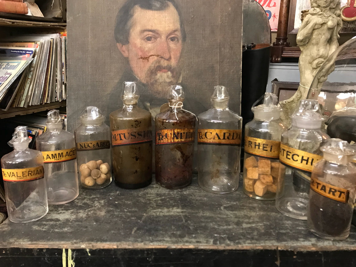 A collection of nine gilt label glass apothecary bottles