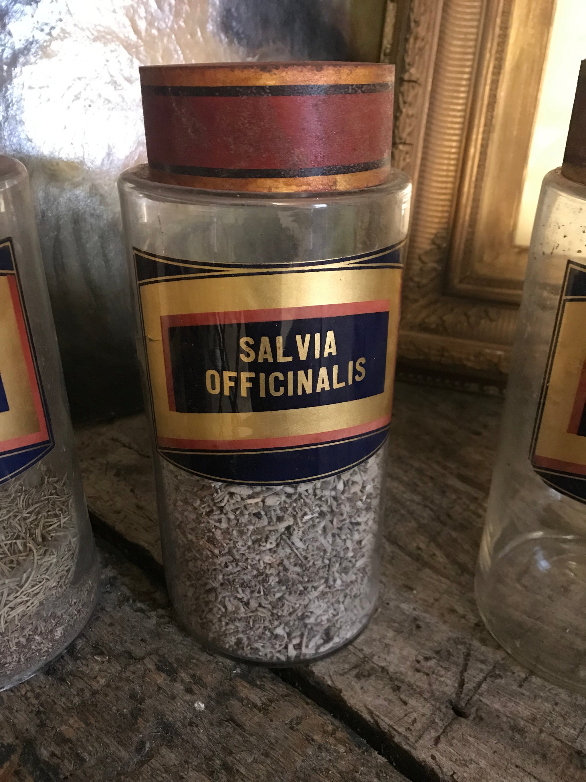 A collection of six gilt label large glass apothecary jars