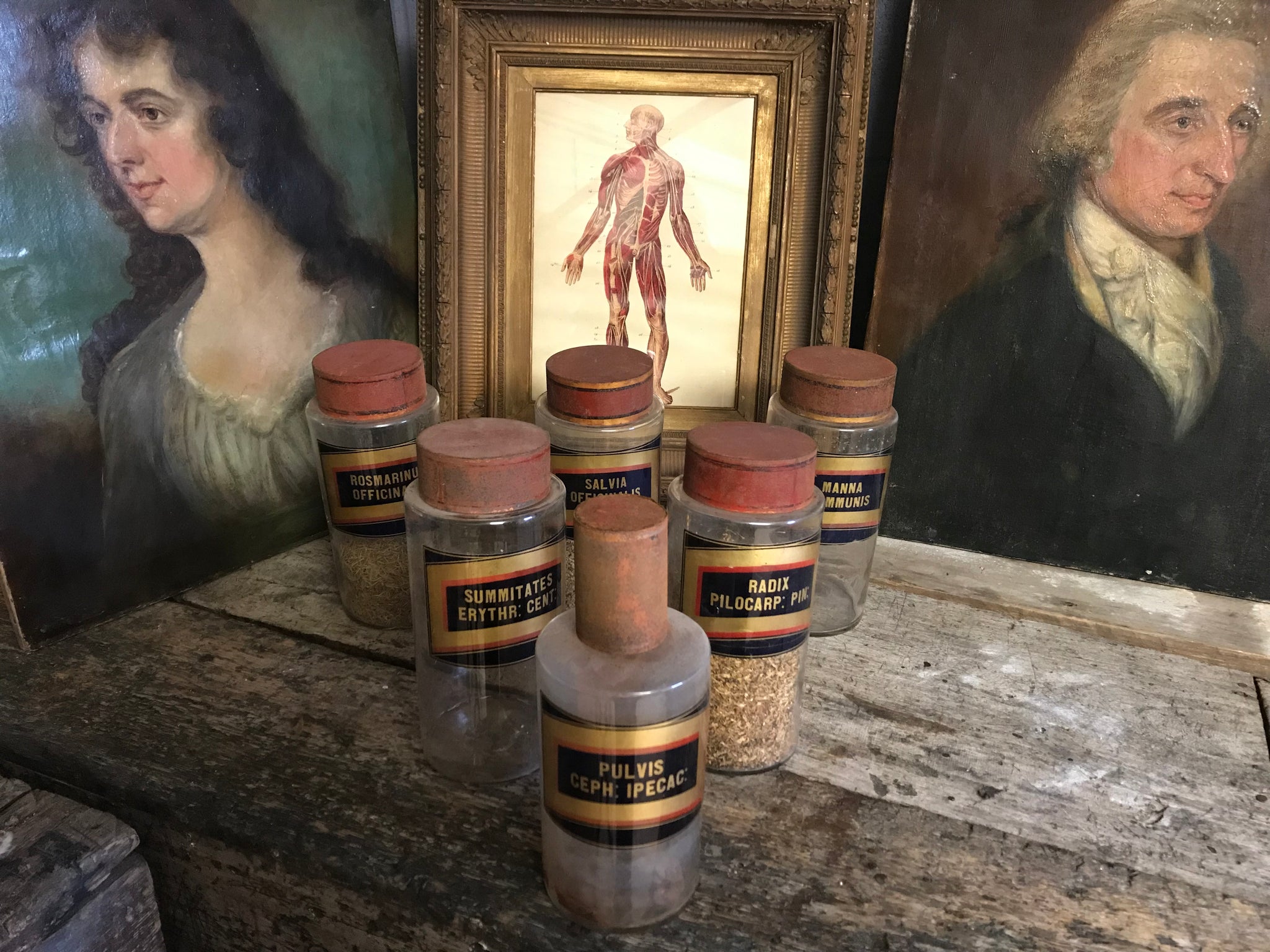 A collection of six gilt label large glass apothecary jars