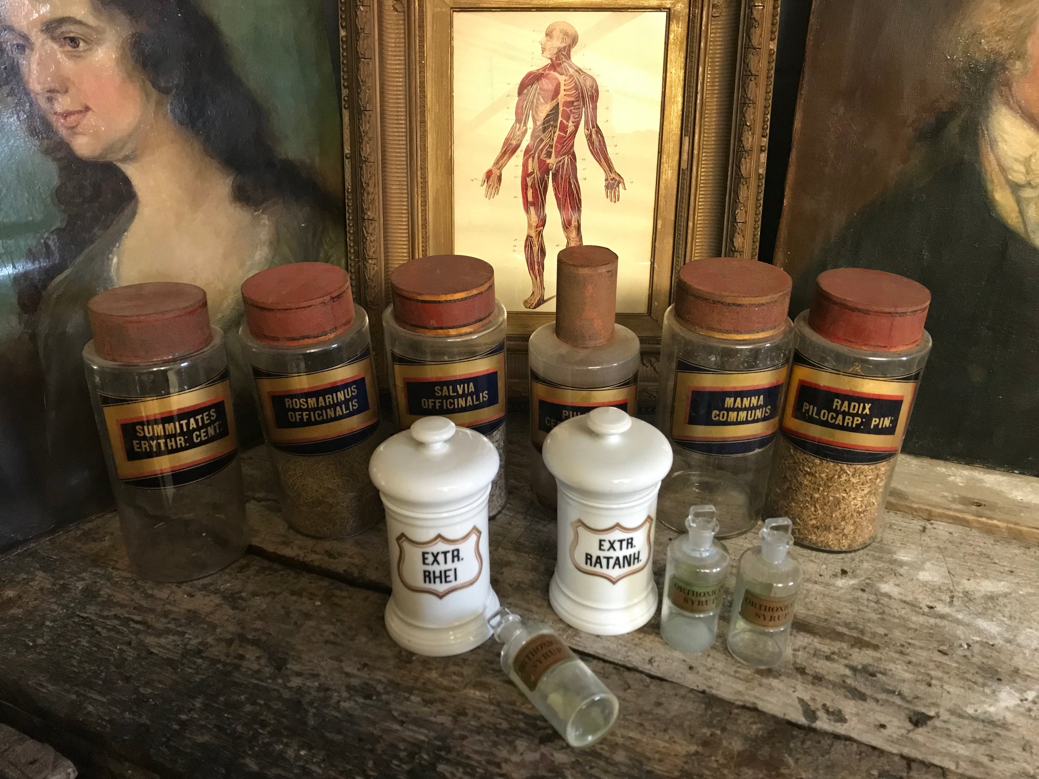 A collection of six gilt label large glass apothecary jars