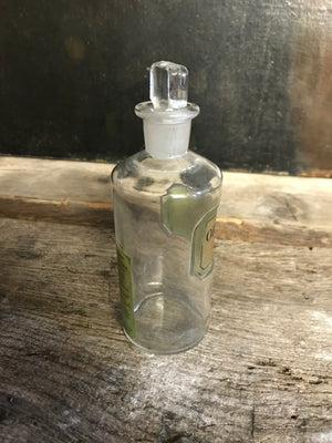 A small glass Orthoxicol Syrup apothecary bottle