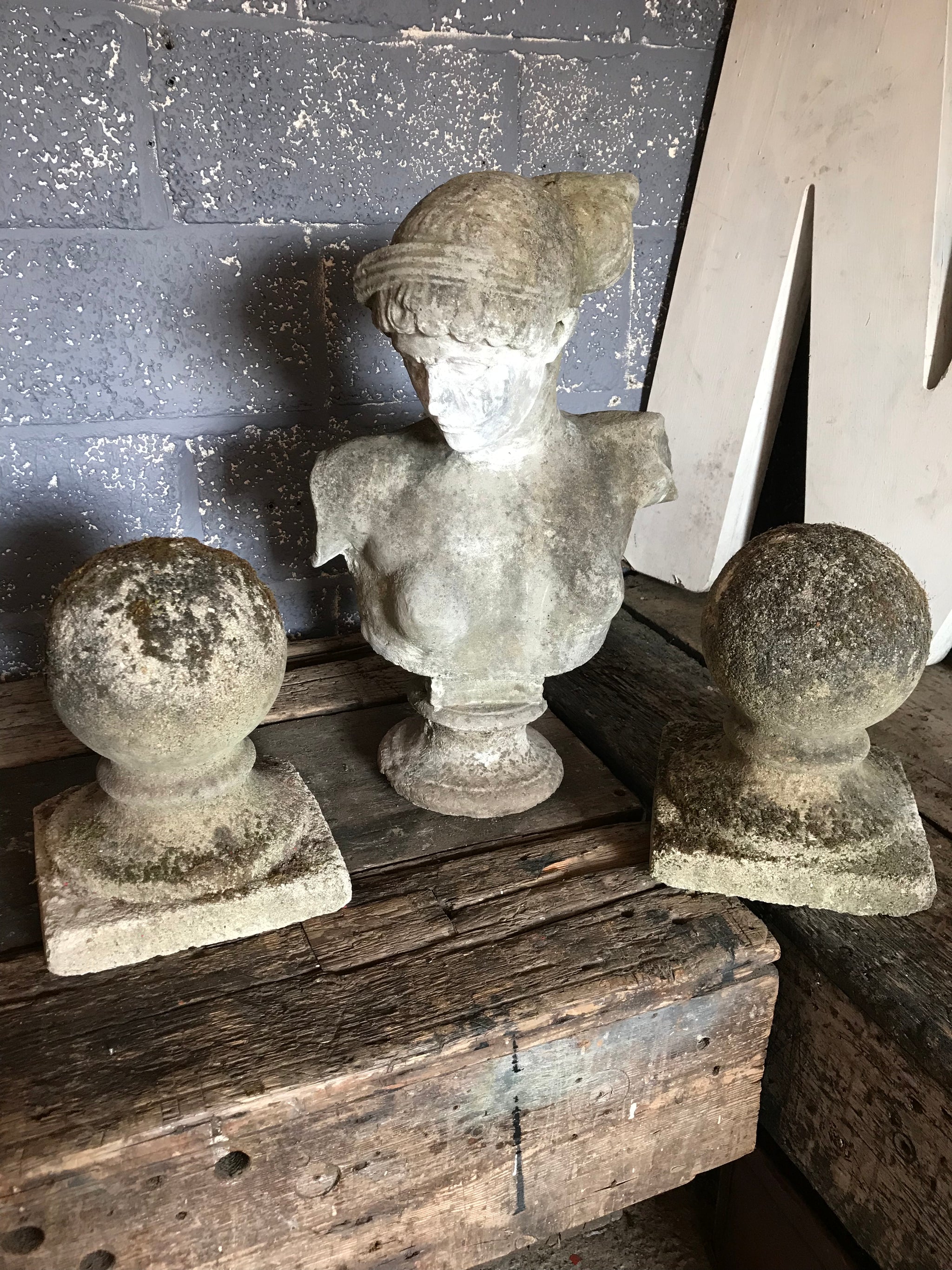 A pair of mossy stone ball pillar caps