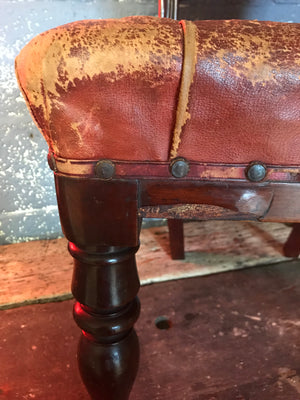 A balloon back upright red leather chair with button back and seat