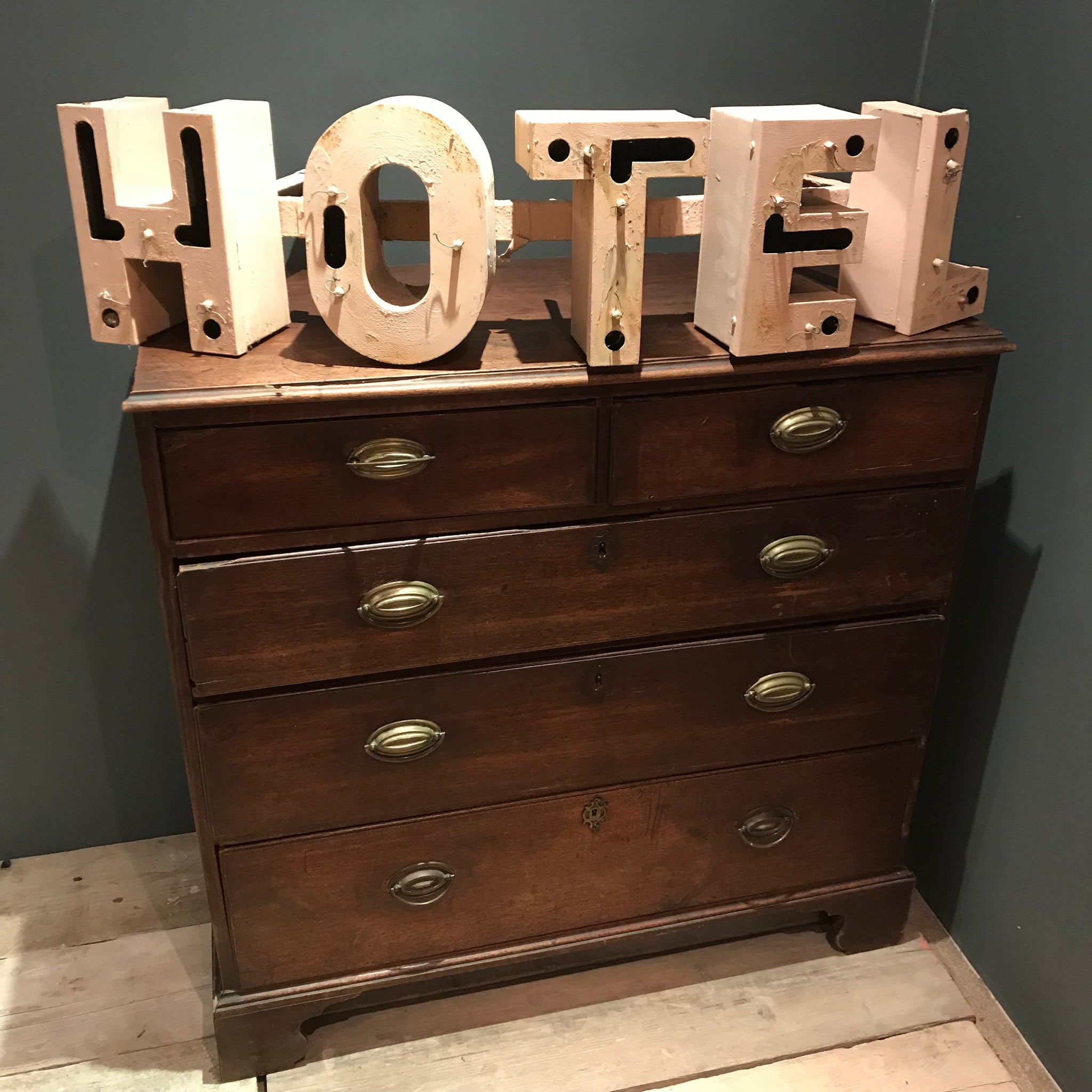 A salvaged pink metal illuminated HOTEL neon advertising sign