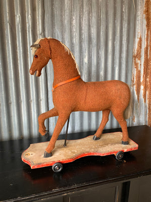 A large pull along rocking horse on wheels