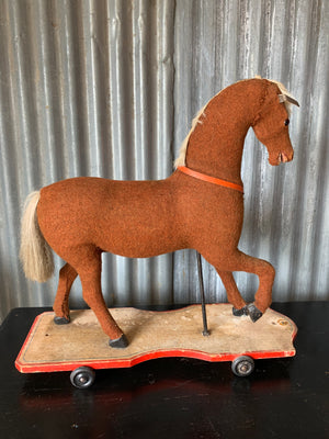 A large pull along rocking horse on wheels