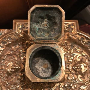 A rococo brass cherub and lion head inkwell and pen tray
